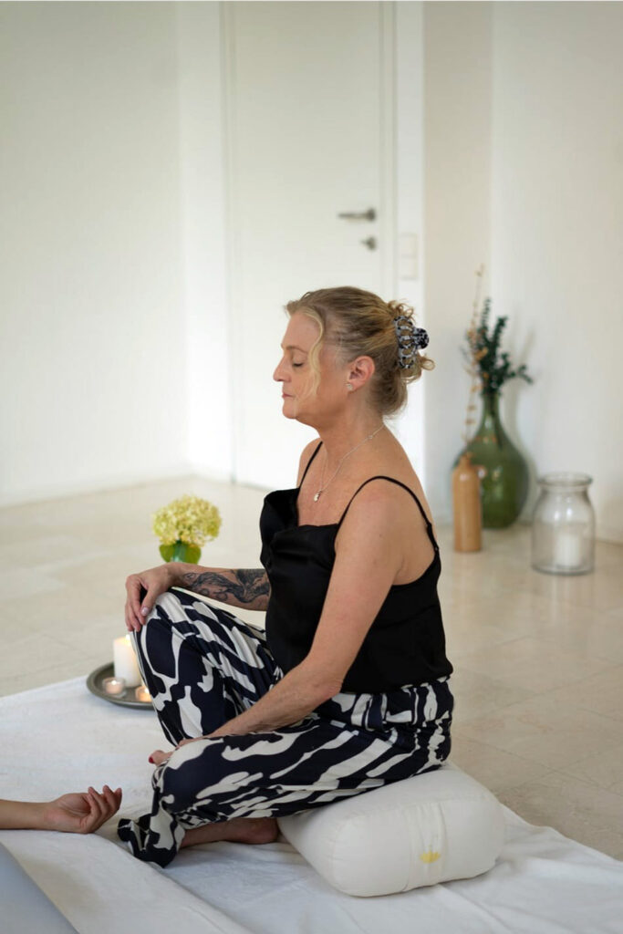 In meditativer Haltung hält Heike Wangler achtsam Raum für den inneren Prozess ihrer Klient:innen.