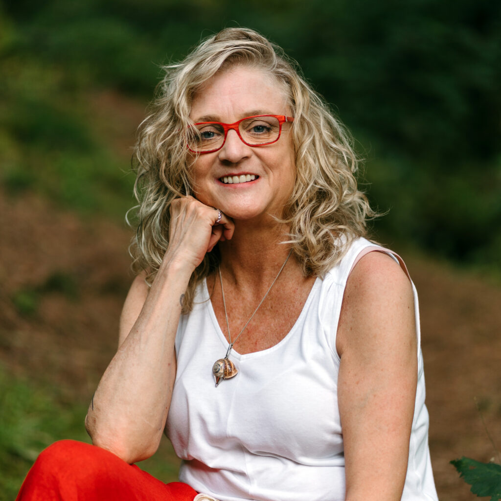 Porträt von Heike Wangler, lachend stützt sie ihren Kopf auf ihre Hand